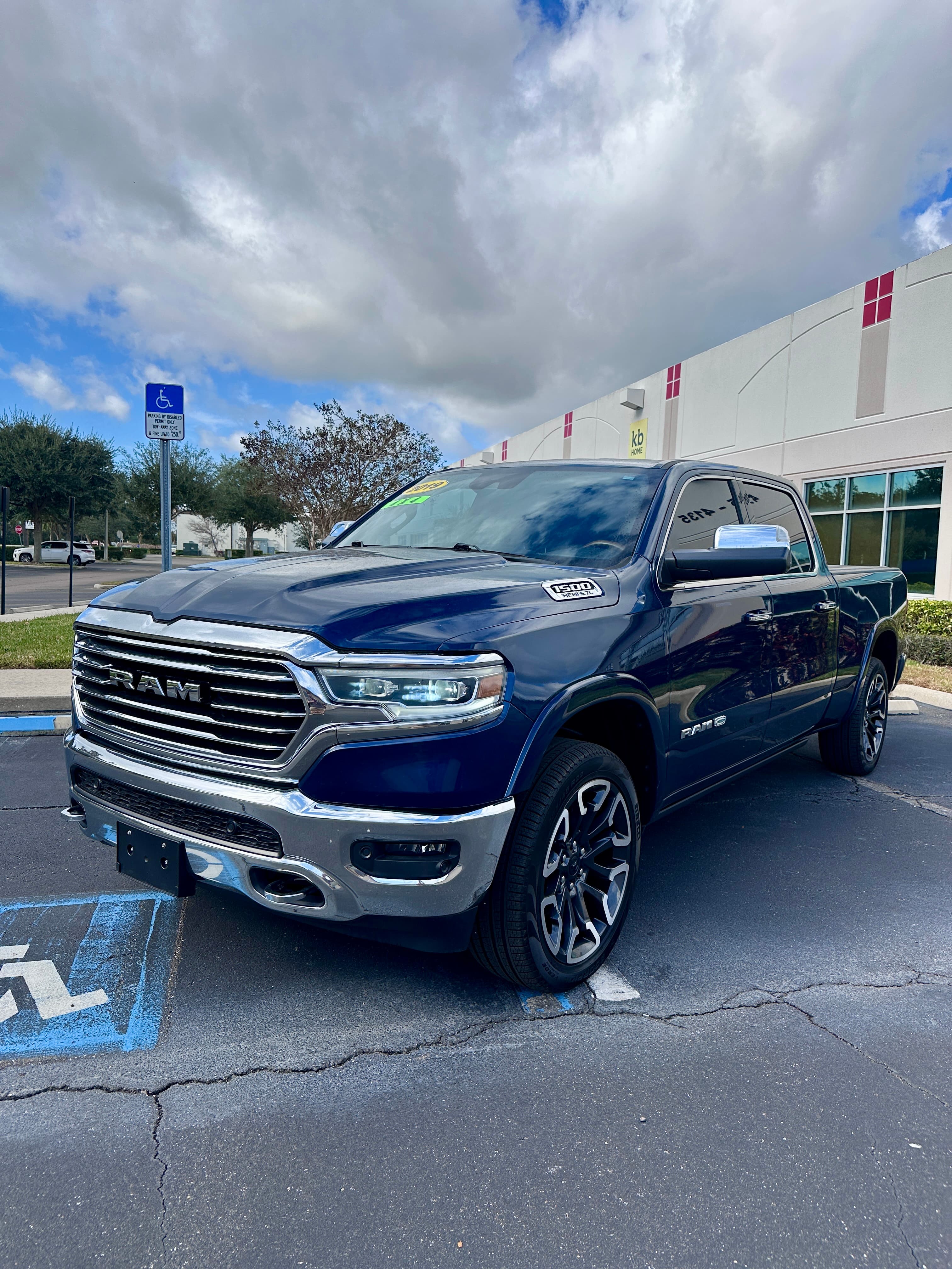 Navy blue Ram 1500 pickup truck with chrome accents parked in a parking lot.